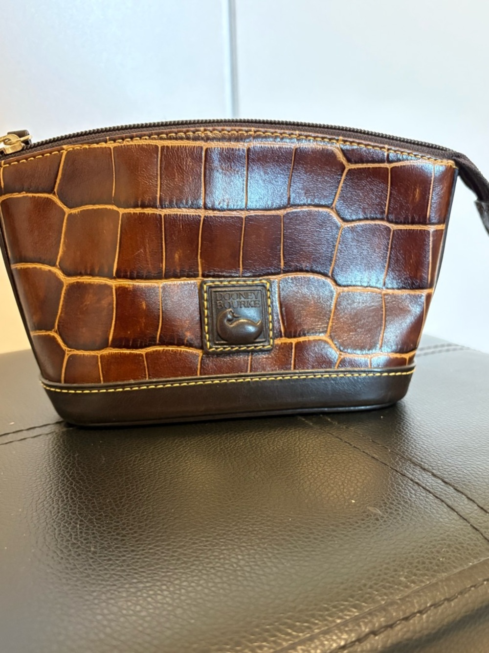 Medium size Dooney and Bourke embossed cosmetic bag/wristlet with top zip